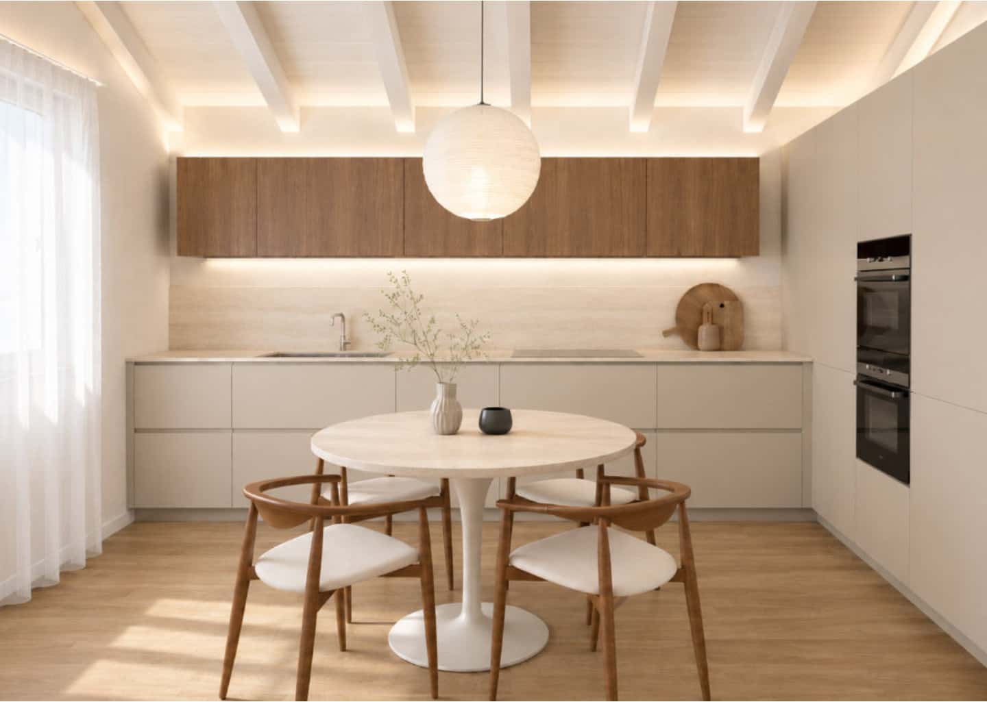 Cucina moderna nei toni neutri con tavolo rotondo in travertino, sedie in legno e pensili a soffitto.